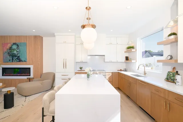 a large white kitchen with a large window