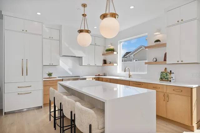 a kitchen with a sink a center island cabinets and stainless steel appliances