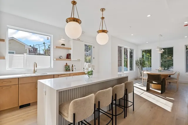 a dining room with wooden floor a chandelier a glass table and chairs