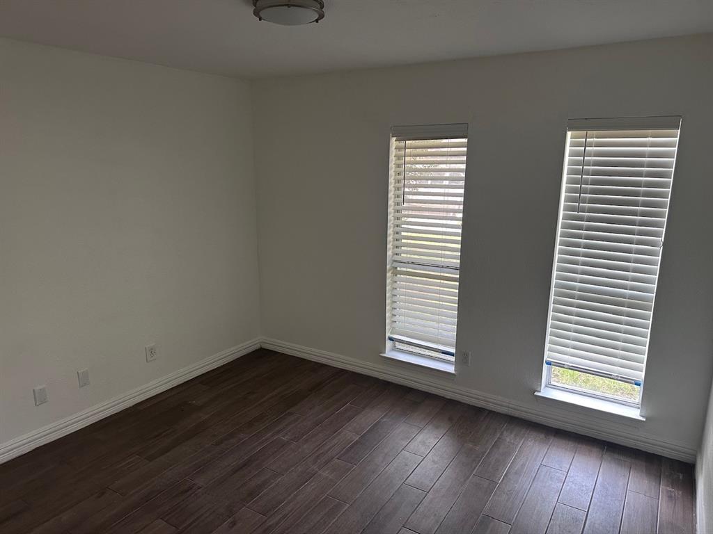 2103 Carlton Road Carrollton, TX 75007 - Photo 3 of 18 an empty room with wooden floor and windows