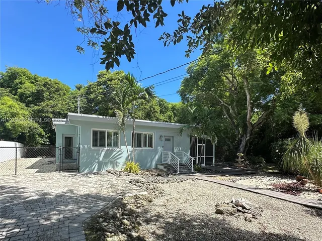 a front view of a house with a tree in a yard