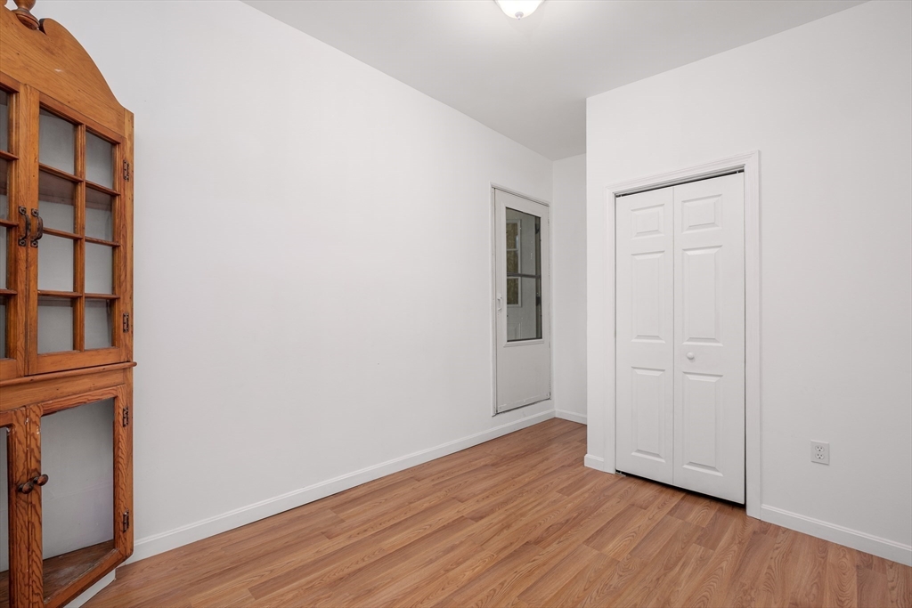 20 Hatch Street Everett, MA 02149 - Photo 14 of 16 an empty room with wooden floor and closet