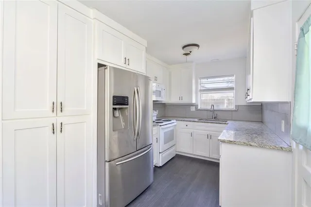 a kitchen with a refrigerator sink and cabinets