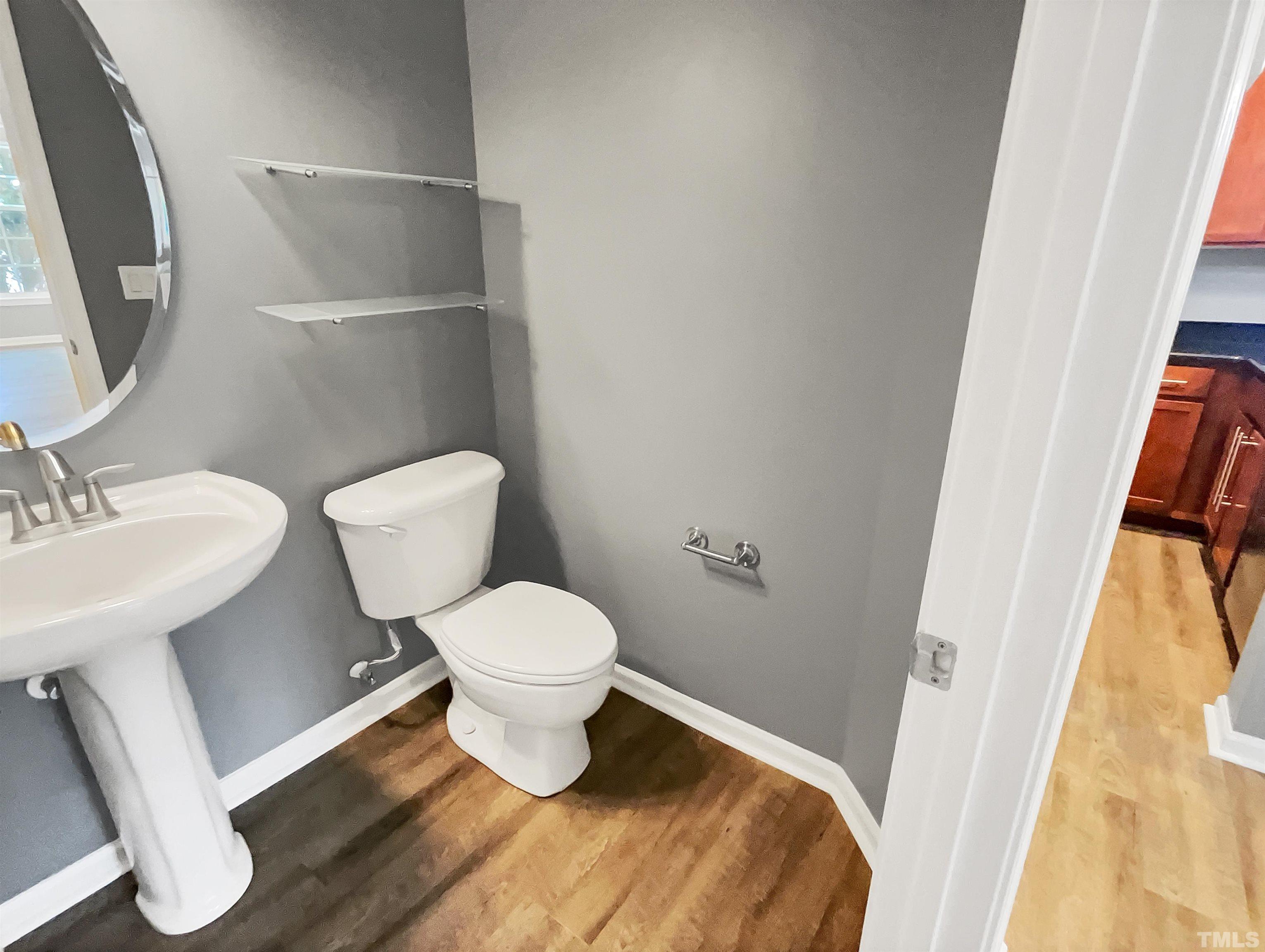 1111 Consortium Drive, Unit 101 Raleigh, NC 27603 - Photo 12 of 17 a bathroom with a toilet sink and a mirror