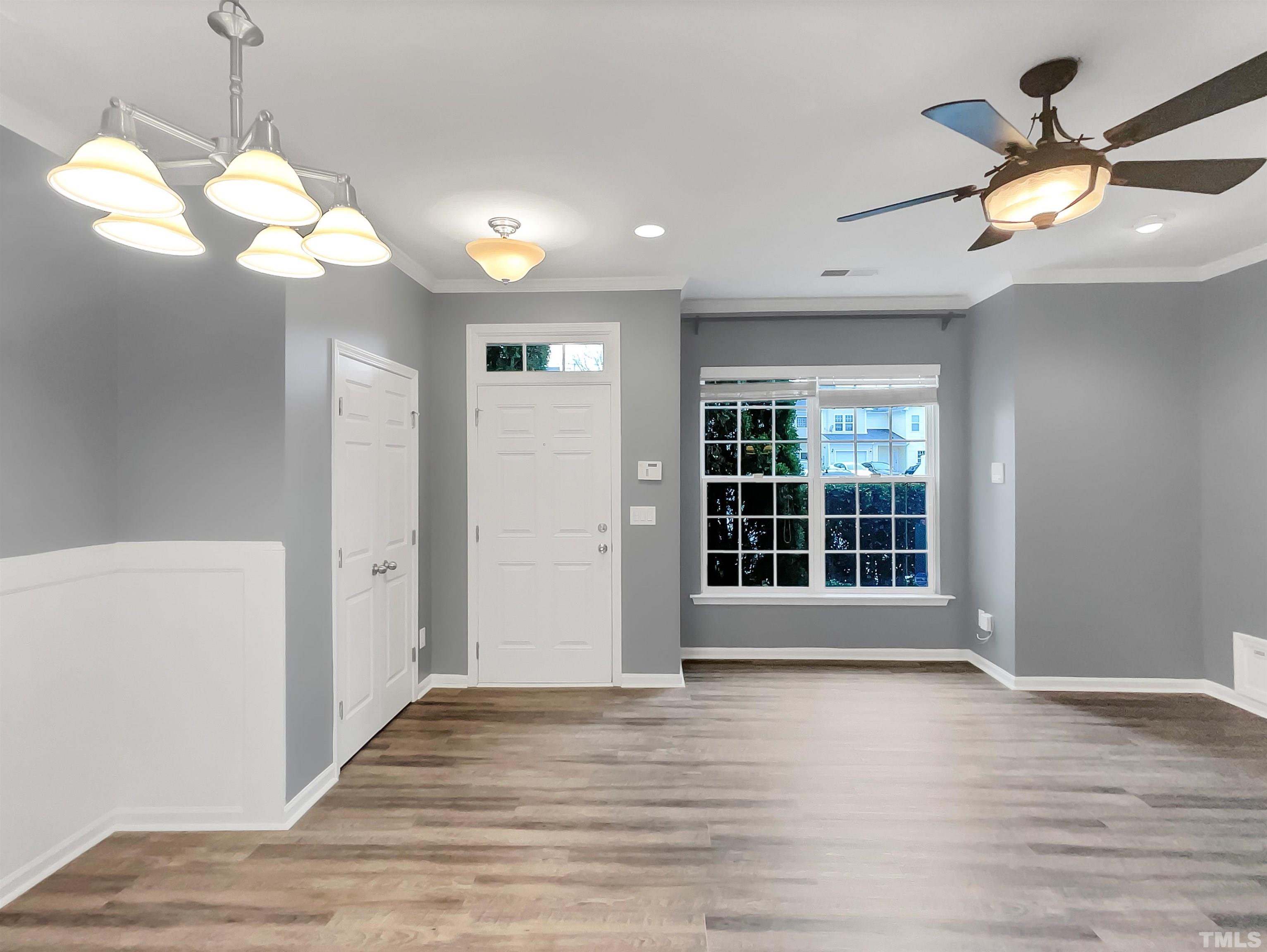 1111 Consortium Drive, Unit 101 Raleigh, NC 27603 - Photo 3 of 17 a view of an empty room with wooden floor and a window