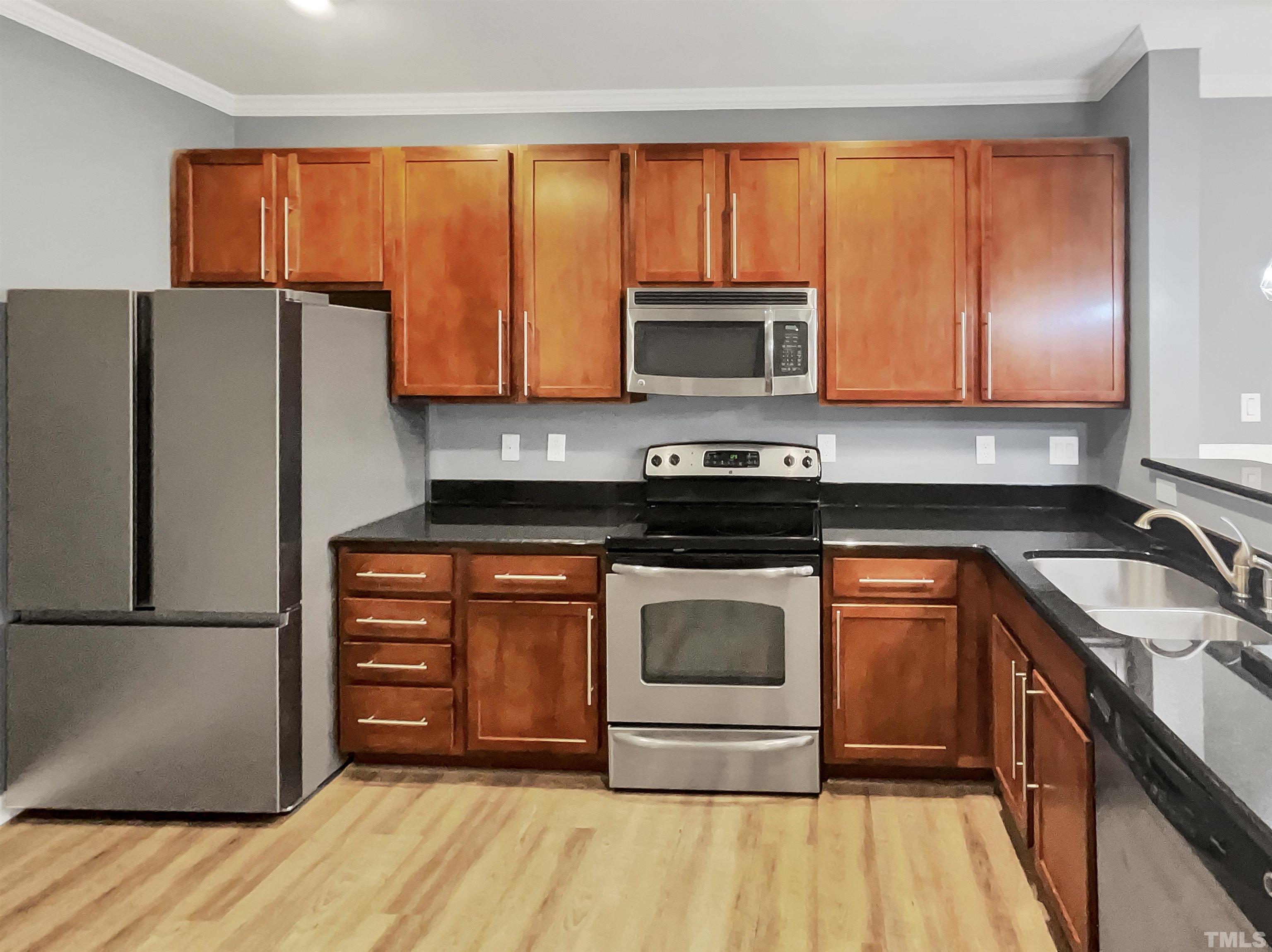 1111 Consortium Drive, Unit 101 Raleigh, NC 27603 - Photo 5 of 17 a kitchen with a refrigerator stove and microwave