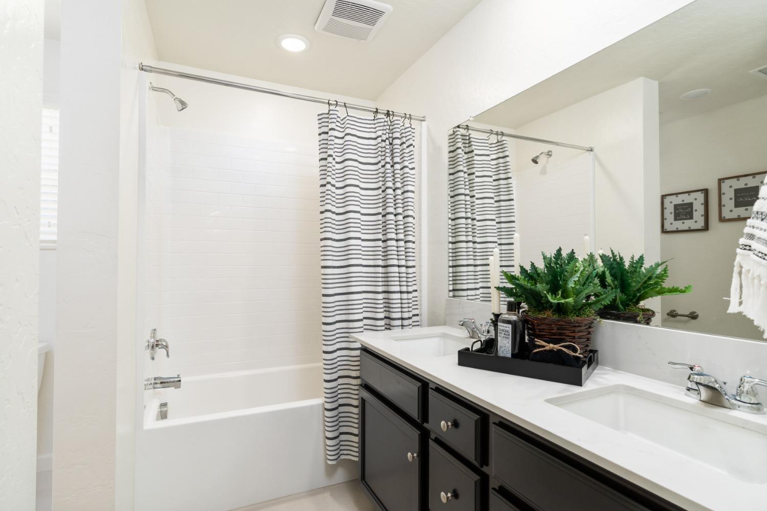 1198 Significant Way West Madera, CA 93636 - Photo 28 of 29 a bathroom with a sink a large mirror and a shower