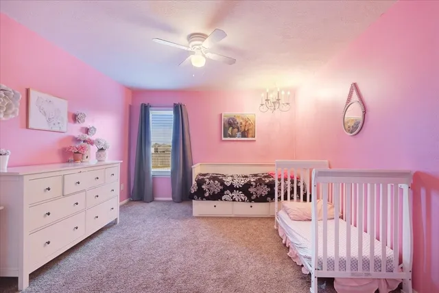 a spacious bedroom with a bed and a chandelier