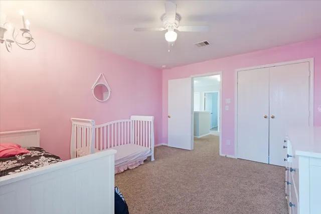 a bedroom with furniture and a chandelier fan