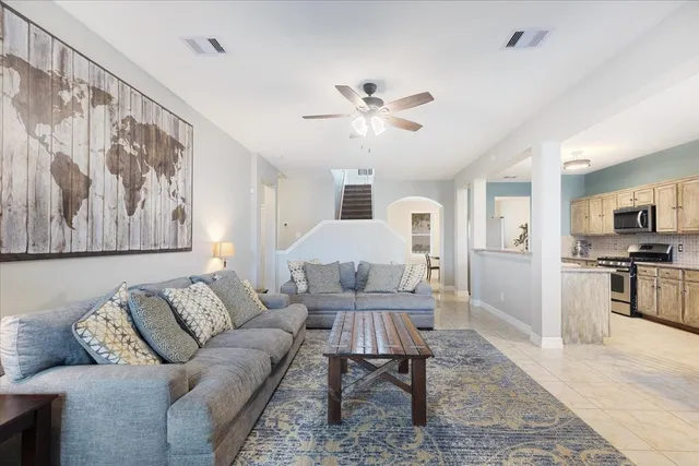 a living room with furniture and a view of kitchen
