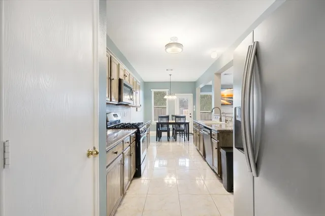 a kitchen with stainless steel appliances granite countertop a refrigerator and a sink