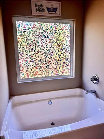 a bath tub sitting in a bathroom next to a window