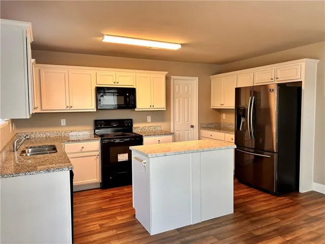 a kitchen with a refrigerator stove and wooden cabinets