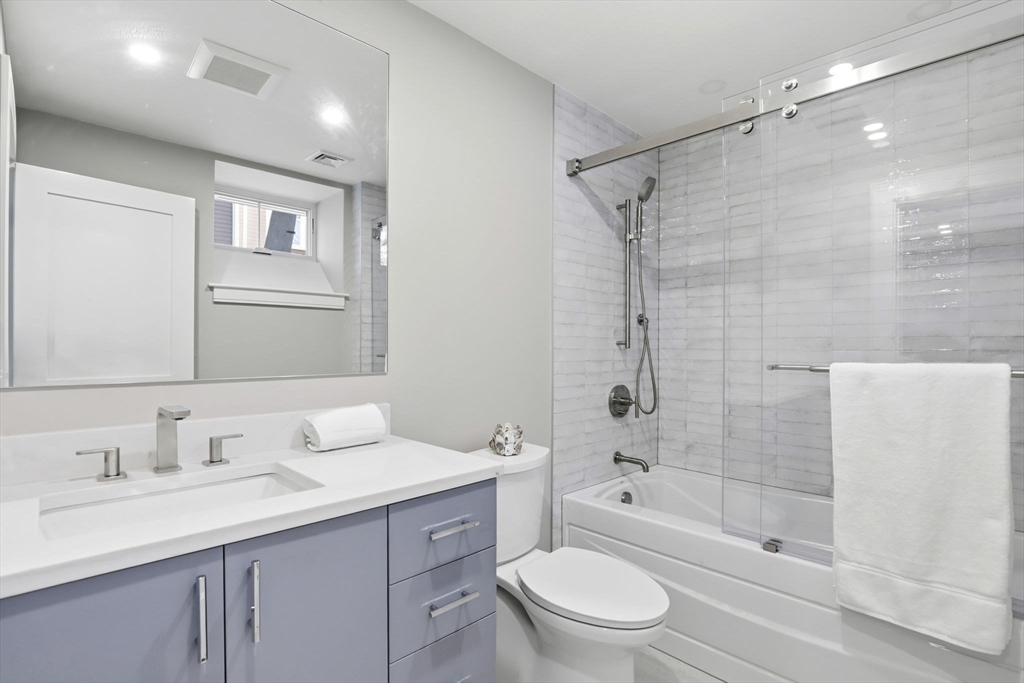 90 Addington Road, Unit 1 Brookline, MA 02445 - Photo 20 of 24 a bathroom with a granite countertop sink toilet and shower