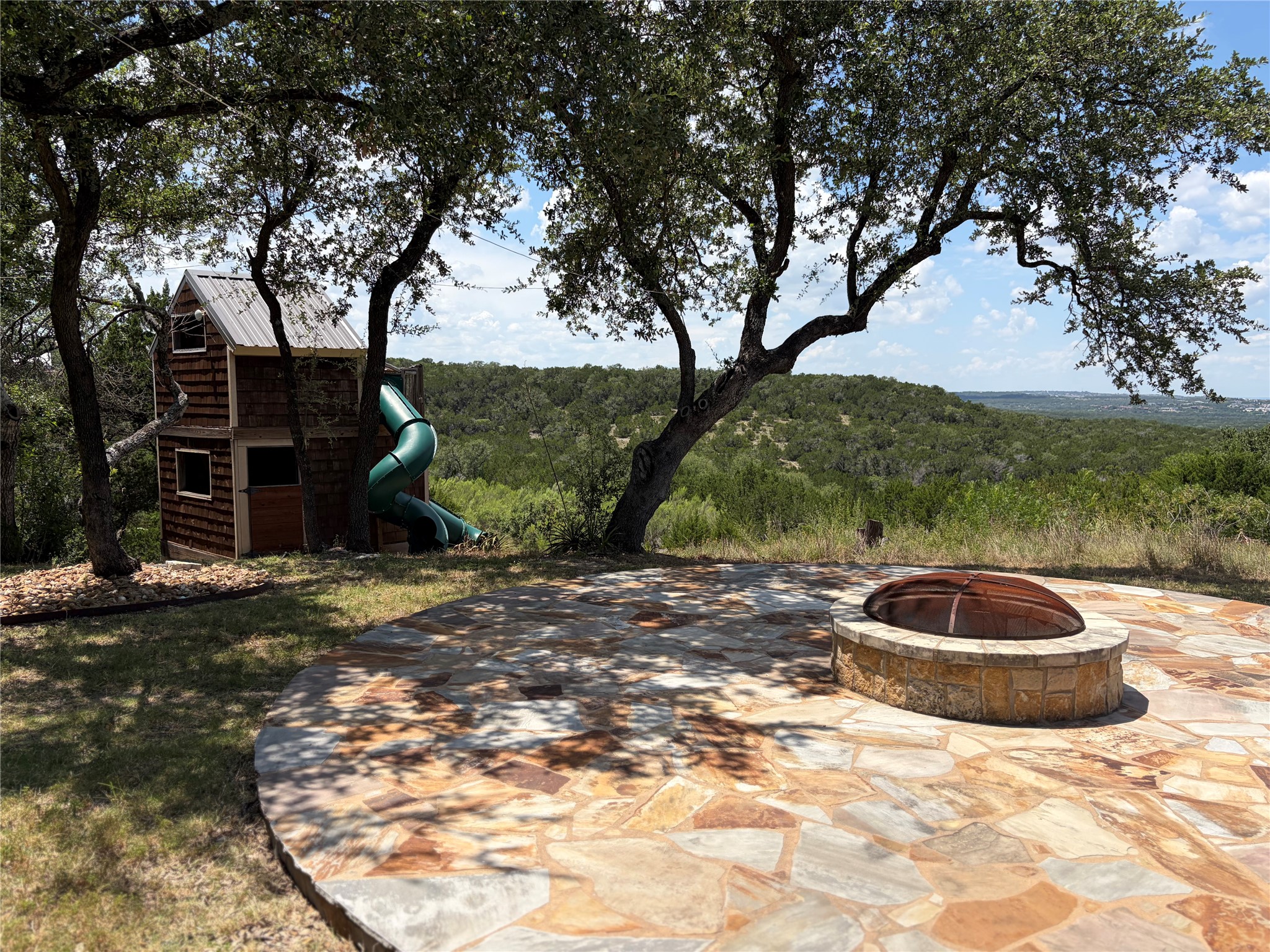7801 Aria Loop Austin, TX 78736 - Photo 21 of 40 Firepit is perfect for roasting smores while you soak in the hill country Views
Kid’s dream 2 story playhouse with 2 slides is nestled to one side