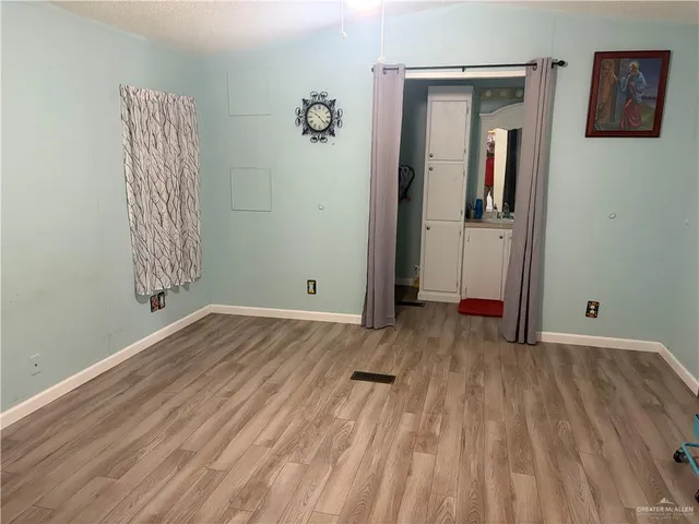 a kitchen with a refrigerator wooden floor and a view of living room