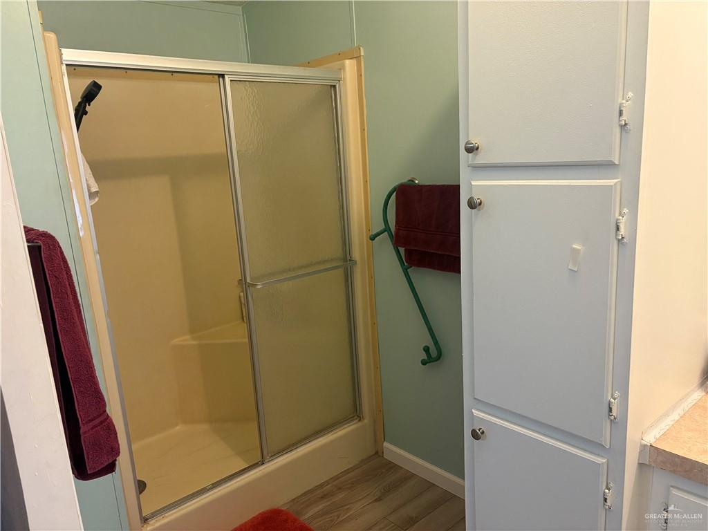 2515 Meadowlark Street Palmview, TX 78572 - Photo 17 of 26 Bathroom with wood finished floors, a shower stall, and vanity