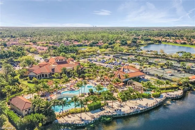 an aerial view of residential houses with outdoor space and lake view