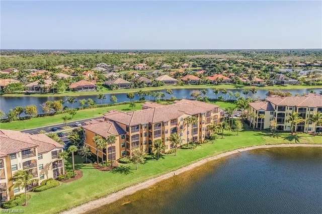 an aerial view of a city with lots of residential buildings ocean and mountain view in back