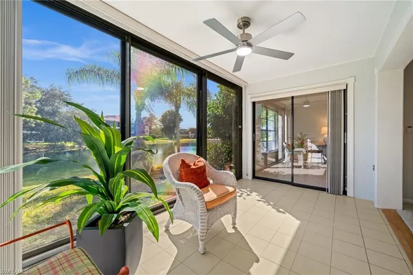 a living room with patio furniture and a potted plant