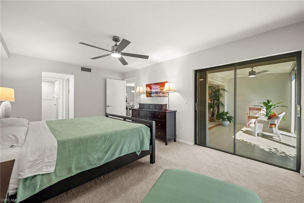 500 Misty Pines Circle, Unit 2103 Naples, FL 34105 - Photo 21 of 38 a bedroom with a large bed and a chandelier