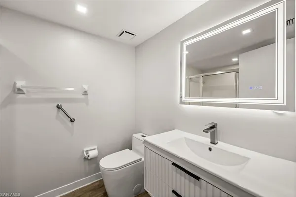 a bathroom with a sink toilet and mirror