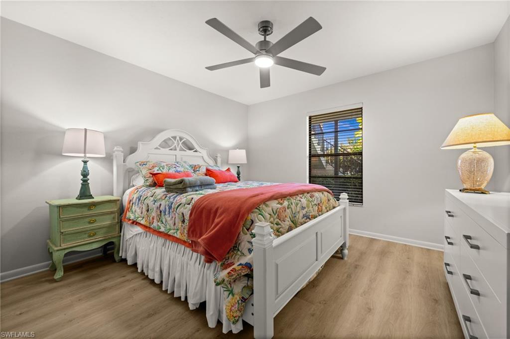 500 Misty Pines Circle, Unit 2103 Naples, FL 34105 - Photo 24 of 38 a bedroom with a bed and a chandelier