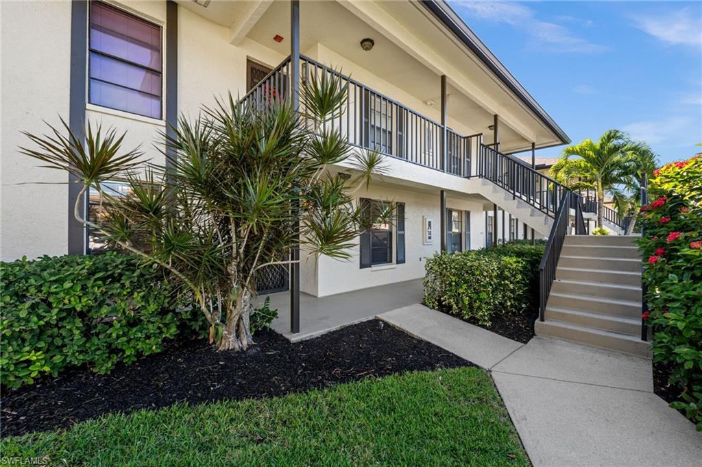 500 Misty Pines Circle, Unit 2103 Naples, FL 34105 - Photo 27 of 38 a front view of a house with a yard