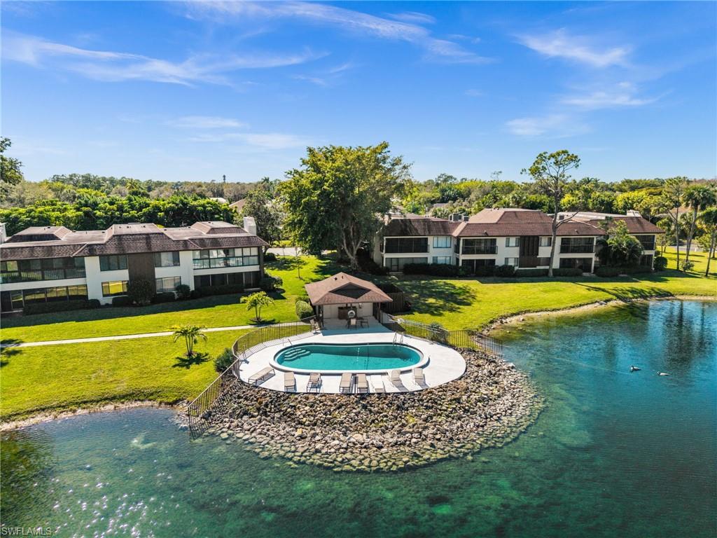 500 Misty Pines Circle, Unit 2103 Naples, FL 34105 - Photo 36 of 38 a view of a swimming pool with an outdoor seating and a garden