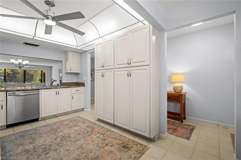 500 Misty Pines Circle, Unit 2103 Naples, FL 34105 - Photo 4 of 38 a kitchen with white cabinets and white appliances