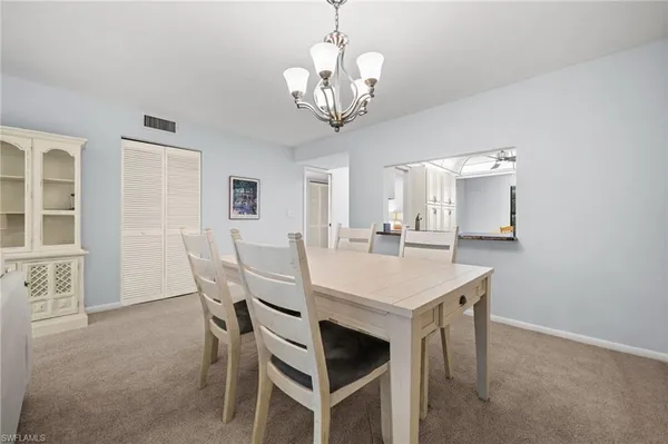 a view of a dining room with furniture and chandelier