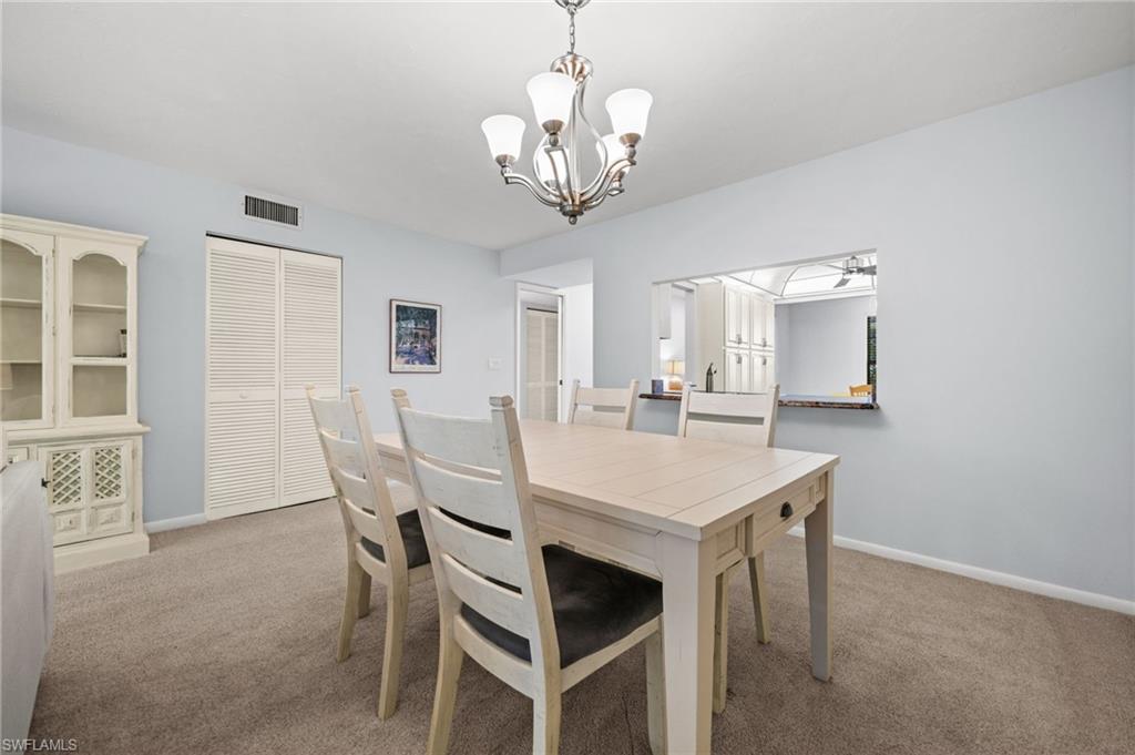 500 Misty Pines Circle, Unit 2103 Naples, FL 34105 - Photo 9 of 38 a view of a dining room with furniture and chandelier