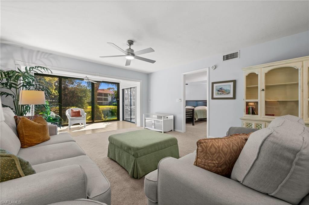 500 Misty Pines Circle, Unit 2103 Naples, FL 34105 - Photo 10 of 38 a living room with furniture and a large window