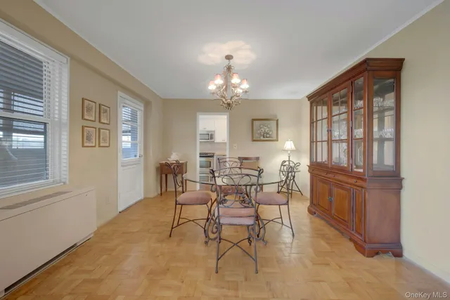 a dining room with chandelier and wooden floor
