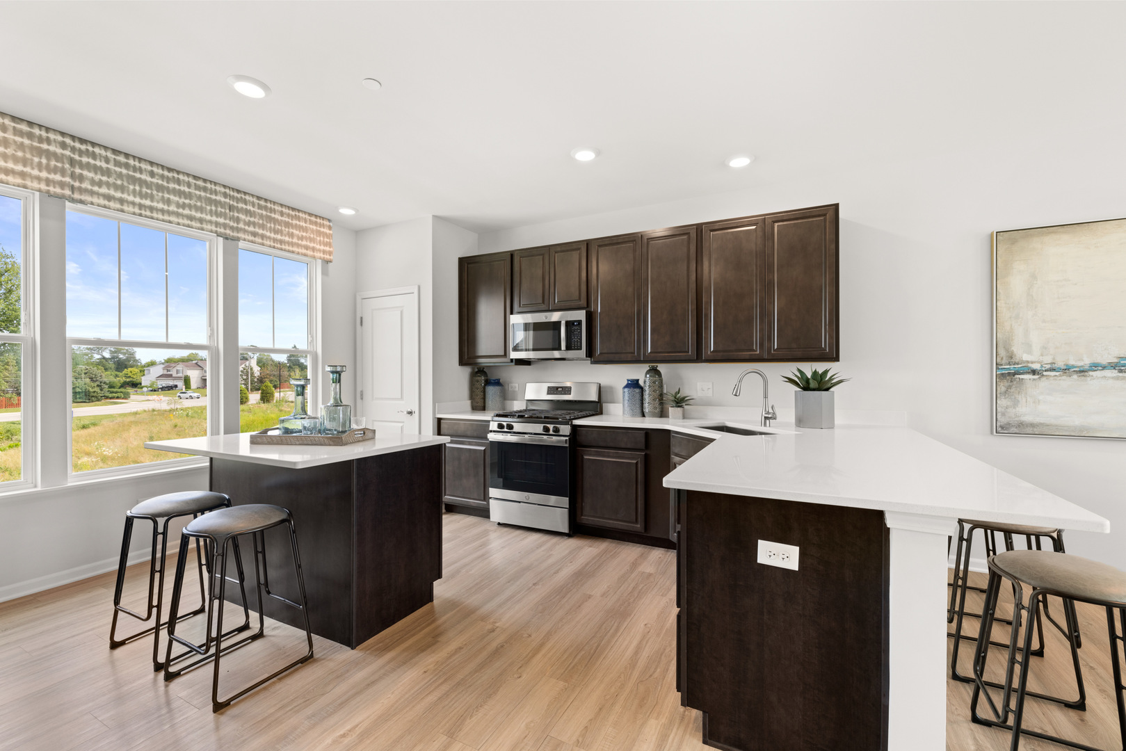 580 Wolverine Drive Aurora, IL 60502 - Photo 5 of 30 a kitchen with kitchen island granite countertop wooden floors and black stainless steel appliances