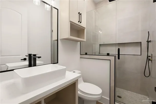 a bathroom with a sink a toilet and a mirror