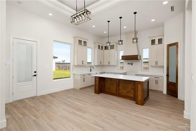 a large kitchen with stainless steel appliances kitchen island granite countertop a large counter top a sink a stove and a refrigerator