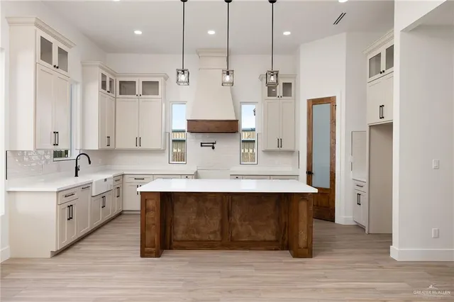 a large kitchen with stainless steel appliances kitchen island granite countertop a sink stove and refrigerator