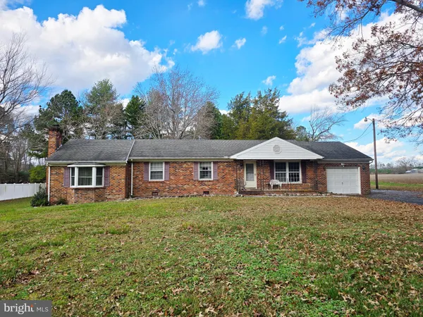 a front view of a house with yard and trees