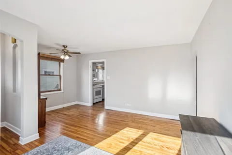 a view of a livingroom with wooden floor and a bedroom