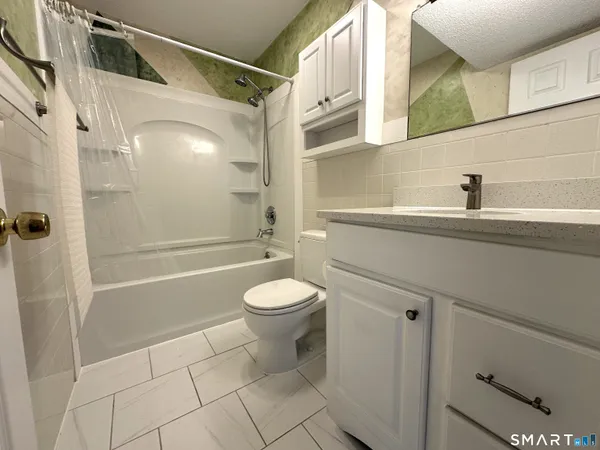 a bathroom with a toilet a sink and shower
