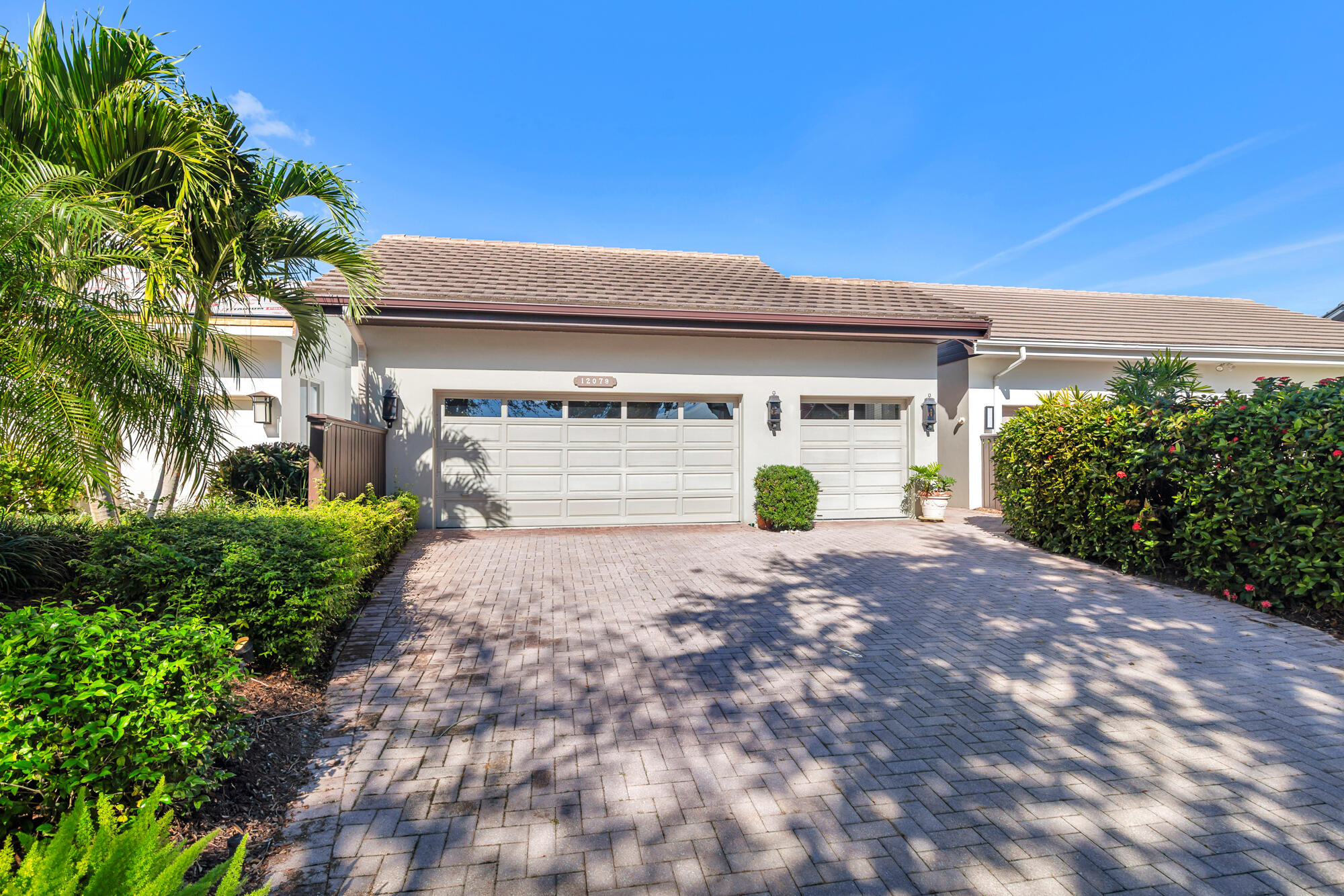 12079 Southeast Birkdale Run Jupiter, FL 33469 - Photo 1 of 50 a front view of a house with a yard and a garage