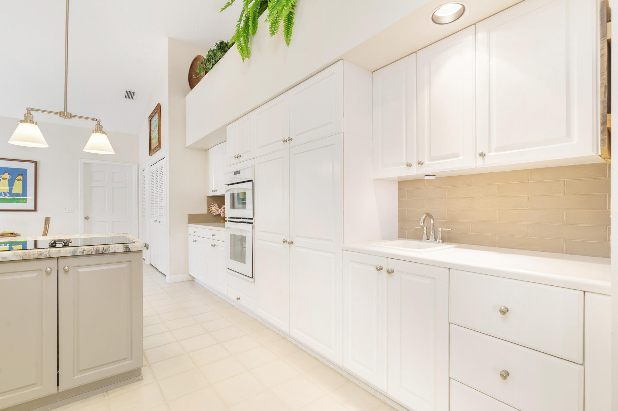 12079 Southeast Birkdale Run Jupiter, FL 33469 - Photo 12 of 50 a kitchen with cabinets and white appliances