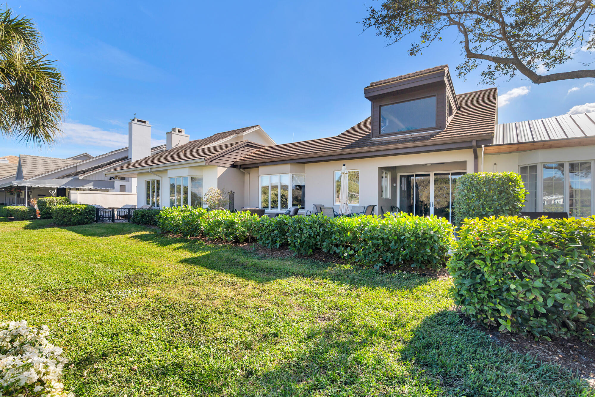 12079 Southeast Birkdale Run Jupiter, FL 33469 - Photo 35 of 50 a view of a white house with a big yard and potted plants