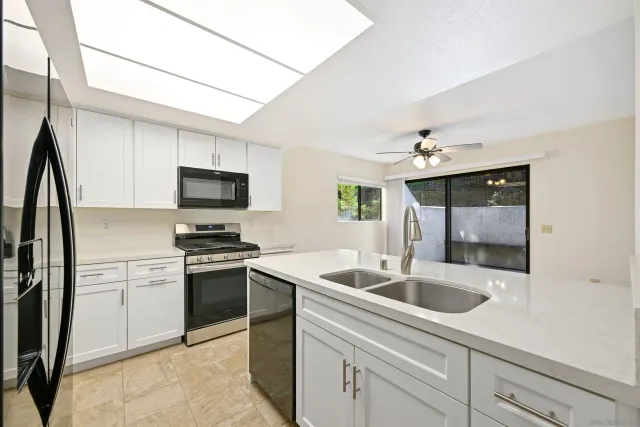 a kitchen with stainless steel appliances granite countertop a sink and a stove