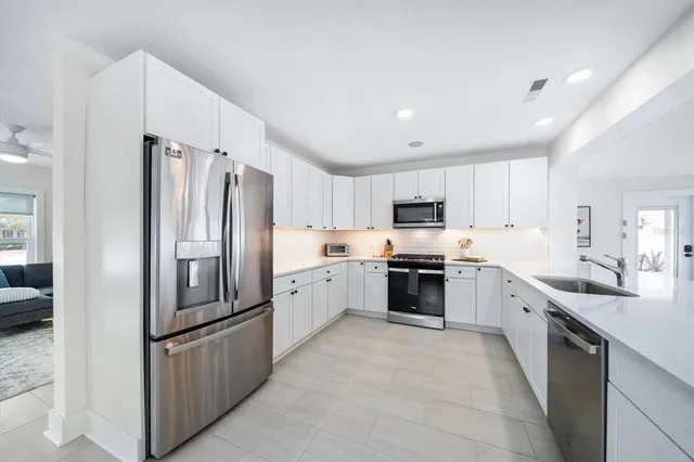 a large kitchen with cabinets stainless steel appliances and a counter space
