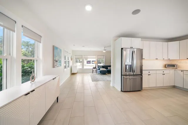 a kitchen with refrigerator and white cabinets