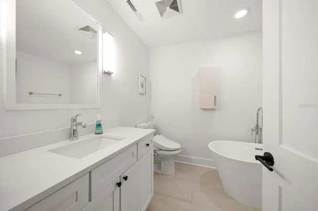 a bathroom with a sink a toilet a mirror and shower