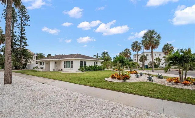 a front view of a house with a garden and yard