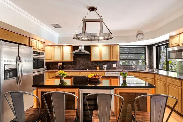 a kitchen with stainless steel appliances granite countertop a sink and a refrigerator